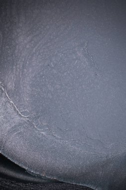 Dramatik siyah, tek renkli soyutlama, ejderha pullarını ya da kek lavlarını anımsatıyor, koyu gri, gümüş ve bronz aksanlarla parıldıyor. Alkolik mürekkep birbirine karışıyor. Modern bir sanat eserinin parçası..