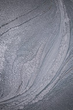 Dramatik siyah, tek renkli soyutlama, ejderha pullarını ya da kek lavlarını anımsatıyor, koyu gri, gümüş ve bronz aksanlarla parıldıyor. Alkolik mürekkep birbirine karışıyor. Modern bir sanat eserinin parçası..