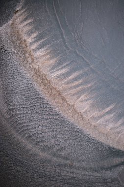 Dramatik siyah, tek renkli soyutlama, ejderha pullarını ya da kek lavlarını anımsatıyor, koyu gri, gümüş ve bronz aksanlarla parıldıyor. Alkolik mürekkep birbirine karışıyor. Modern bir sanat eserinin parçası..