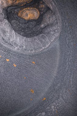 Dramatik siyah, tek renkli soyutlama, ejderha pullarını ya da kek lavlarını anımsatıyor, koyu gri, gümüş ve bronz aksanlarla parıldıyor. Alkolik mürekkep birbirine karışıyor. Modern bir sanat eserinin parçası..