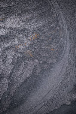 Dramatik siyah, tek renkli soyutlama, ejderha pullarını ya da kek lavlarını anımsatıyor, koyu gri, gümüş ve bronz aksanlarla parıldıyor. Alkolik mürekkep birbirine karışıyor. Modern bir sanat eserinin parçası..