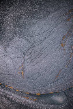 Dramatik siyah, tek renkli soyutlama, ejderha pullarını ya da kek lavlarını anımsatıyor, koyu gri, gümüş ve bronz aksanlarla parıldıyor. Alkolik mürekkep birbirine karışıyor. Modern bir sanat eserinin parçası..