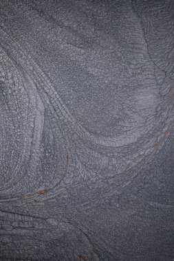 Dramatik siyah, tek renkli soyutlama, ejderha pullarını ya da kek lavlarını anımsatıyor, koyu gri, gümüş ve bronz aksanlarla parıldıyor. Alkolik mürekkep birbirine karışıyor. Modern bir sanat eserinin parçası..