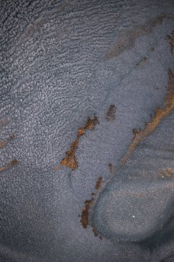 Dramatik siyah, tek renkli soyutlama, ejderha pullarını ya da kek lavlarını anımsatıyor, koyu gri, gümüş ve bronz aksanlarla parıldıyor. Alkolik mürekkep birbirine karışıyor. Modern bir sanat eserinin parçası..