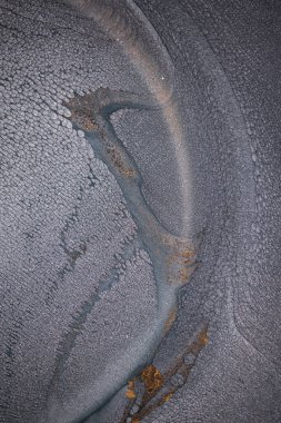 Dramatik siyah, tek renkli soyutlama, ejderha pullarını ya da kek lavlarını anımsatıyor, koyu gri, gümüş ve bronz aksanlarla parıldıyor. Alkolik mürekkep birbirine karışıyor. Modern bir sanat eserinin parçası..