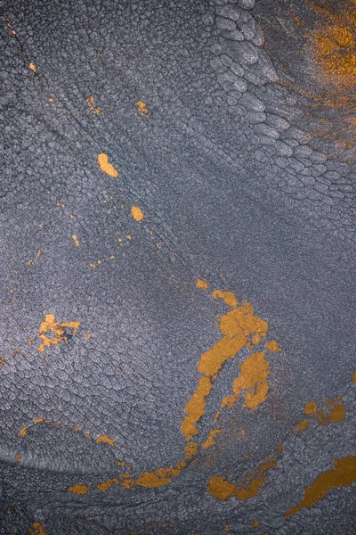 Dramatik siyah, tek renkli soyutlama, ejderha pullarını ya da kek lavlarını anımsatıyor, koyu gri, gümüş ve bronz aksanlarla parıldıyor. Alkolik mürekkep birbirine karışıyor. Modern bir sanat eserinin parçası..