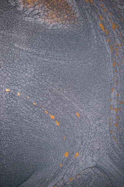 Dramatik siyah, tek renkli soyutlama, ejderha pullarını ya da kek lavlarını anımsatıyor, koyu gri, gümüş ve bronz aksanlarla parıldıyor. Alkolik mürekkep birbirine karışıyor. Modern bir sanat eserinin parçası..