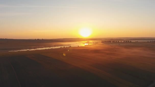 Imágenes de drones cinematográficos de paisajes aéreos al atardecer. Volando por encima de un río en Ucrania con campos en la niebla del atardecer ligero . — Vídeos de Stock