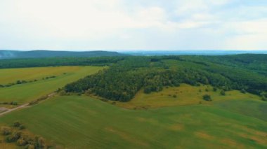 İHA şehir merkezinin dışında, farklı ekinlerle birlikte çok renkli tarım arazilerinin üzerinde uçuyor..