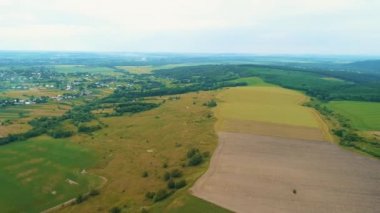 İHA şehir merkezinin dışında, farklı ekinlerle birlikte çok renkli tarım arazilerinin üzerinde uçuyor..