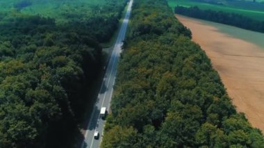 Kamera takip etmek için hareket ediyor ve vahşi ormanlar arasındaki yolda giderken arabayı takip ediyor..