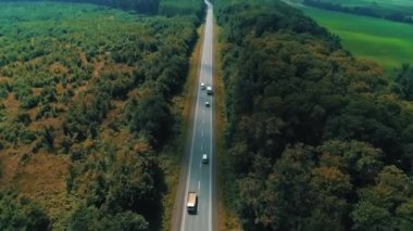 Gün batımından önce güzel kırsal kesimlerde, kamyon ve arabaların hava görüntüleri..