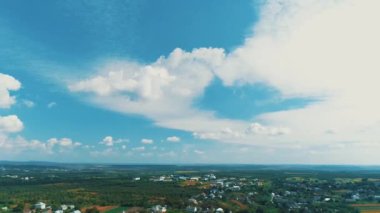 Aerial drone view of morning hour over peaceful countryside with green agricultural fields and houses.