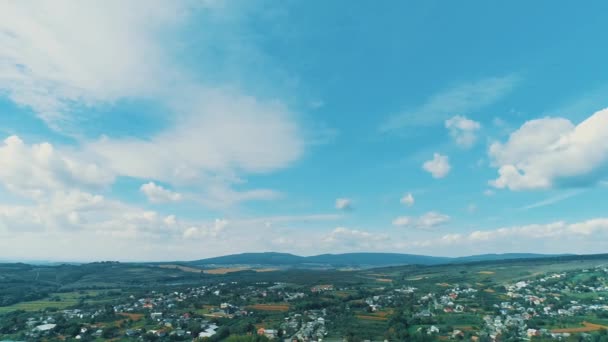 Flying above village with picturesque countryside on sunny pleasant day. — Stock video