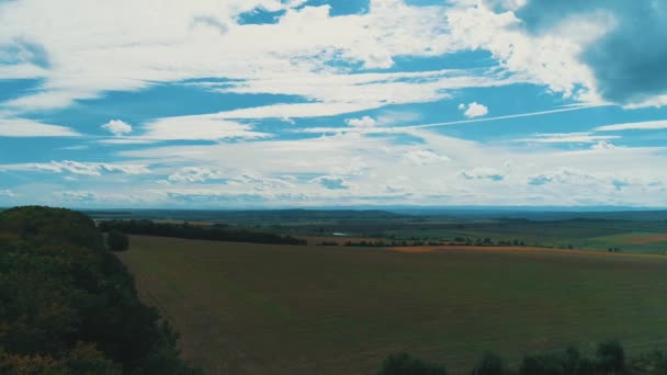 Agricultural field furrows in countryside from above and cloudy blue sky. — Stock video