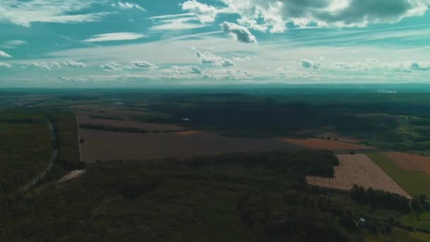 Champ agricole sillonne la campagne par le haut et ciel bleu nuageux .