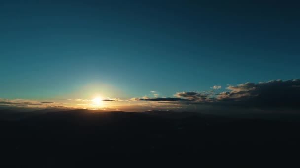 Early morning concept. First sunrays over the mountains with big settlement in darkness at the foot. — ストック動画