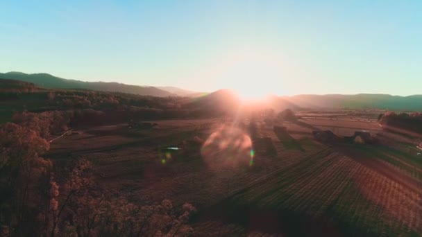 Aerial view of beautiful pink sunset with mountains horizon and village on the bottom in dim light. — Stockvideo