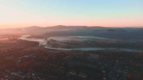 Beautiful misty dawn over the river and mountain settlement on early autumn season. — Stock video