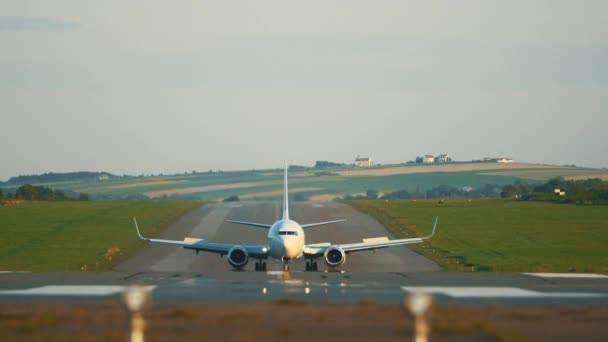 Un video frontale di una pista di atterraggio aeroportuale con un aereo, che scende, atterra e guida verso la telecamera . — Video Stock