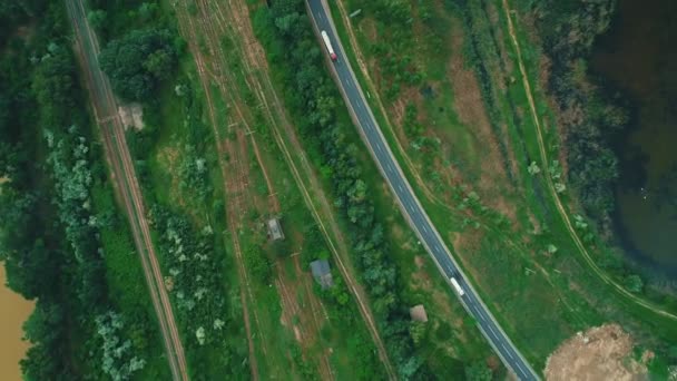 Widok z lotu ptaka na krajobraz wiejski z ruchem drogowym i torami kolejowymi na stronie. — Wideo stockowe