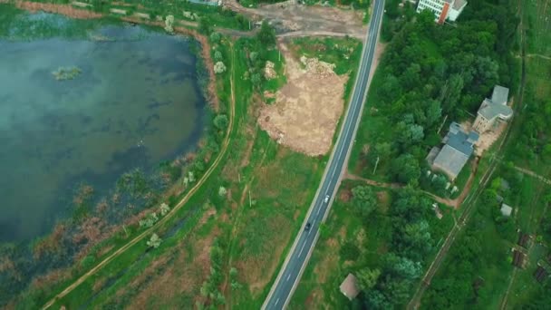 Concetto di attività logistica o di trasporto. Molte file di container da carico su ferrovia in campagna e auto in movimento su strada . — Video Stock