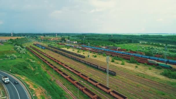 Concept logistique d'entreprise ou de transport. De nombreuses rangées de conteneurs de fret sur le chemin de fer dans les pays et les voitures se déplaçant sur la route . — Video