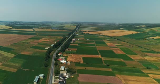 Політ над мальовничим ландшафтом з кількома поселеннями влітку . — стокове відео