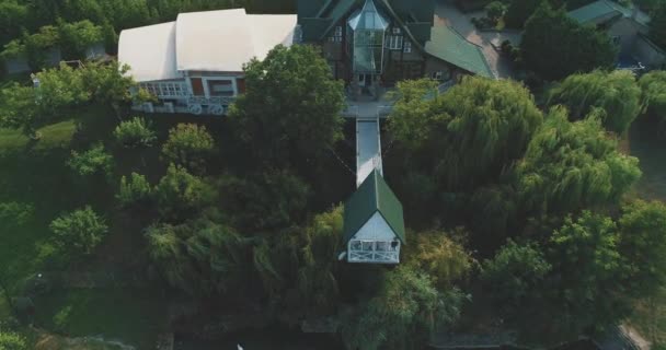 Vista aérea do restaurante com gazebo no lago cercado por parque de verão verde . — Vídeo de Stock