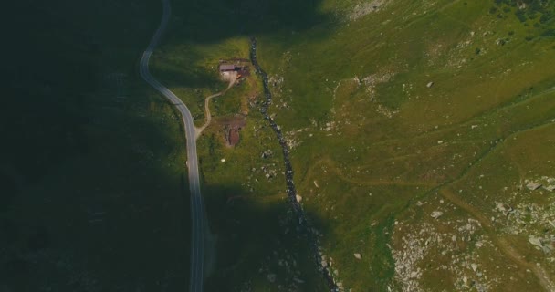 Eenzaam huisje verscholen onder de steile bergen in de uitgestrekte groene wildernis in Roemenië. — Stockvideo