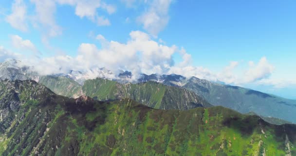 Cumes de montanha alta épica localizado um por um sob cumulus nuvens céu a partir de imagens drone . — Vídeo de Stock