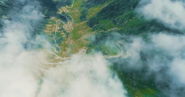 Beautiful landscape view with mountains, road serpantine from above through white light clouds. — Stock Video