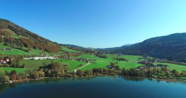 Villaggio verde valle sulle verdi colline ai piedi delle montagne, vicino al lago . — Video Stock