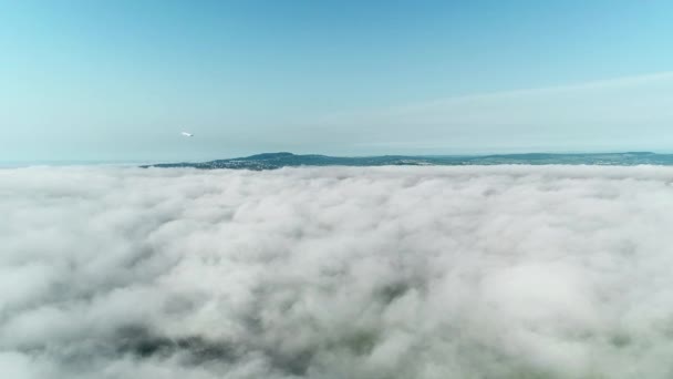 Самолет летит из облаков в голубое небо . — стоковое видео