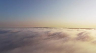 Bulutların ve sislerin üzerinden uçarak güneşe ve ufuktaki dağlara doğru.