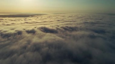 Hareket eden yüzey sisinin destansı panoramik görüntüsü bir kıtayı kaplayan güneş ışınlarıyla ışınlandı. Bunaltıcı gökyüzü manzarası.