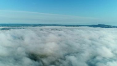 Yaz mevsiminde yeşil yaz manzarasını kaplayan beyaz bulutlar uçuşuyor, yuvarlanıyor ve şekil değiştiriyor..