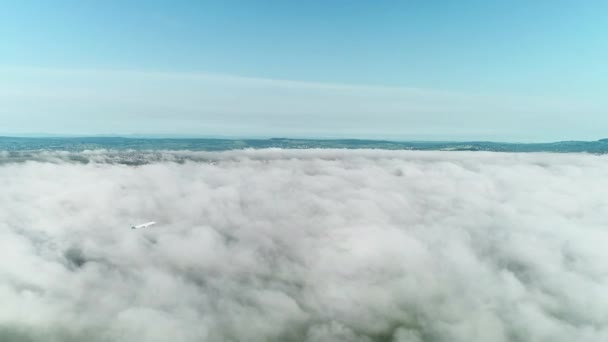 Vliegtuig dat van wolken naar de blauwe lucht vliegt. — Stockvideo