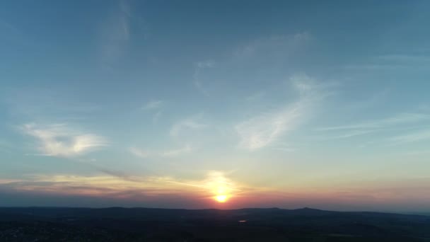 Rood oranje zonsondergang wolkenlandschap boven blauwe avondhemel met bergen silhouet aan de horizon. — Stockvideo