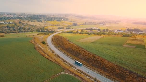 Herfstreis concept. Luchtfoto van de weg in de herfst platteland in gele en oranje kleuren. — Stockvideo