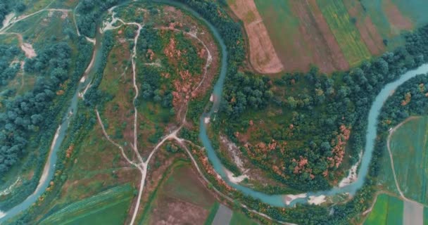Rio sinuoso entre belos prados e campos agrícolas de drone . — Vídeo de Stock