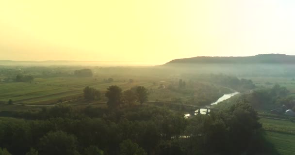 4K antenn utsikt över morgondimman i orange ljus över floden, vid soluppgången. — Stockvideo