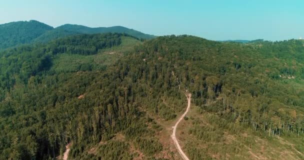 Volar sobre el camino sinuoso delgado en la pendiente de la colina, que conduce a la cima de la montaña . — Vídeos de Stock