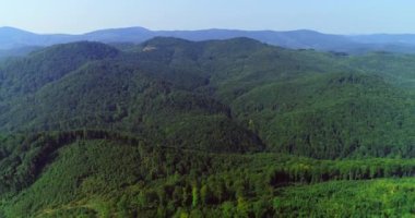 İnsansız hava aracı yeşil dağ manzarası üzerinde uçuyor yaz günü güneş parıldıyor.