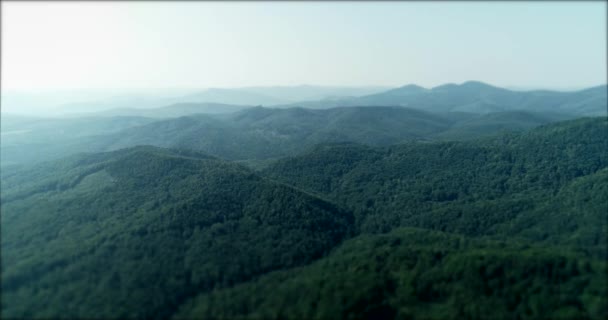 Dron letící nad zelenou horskou krajinou se sluneční erupcí v letním dni. — Stock video