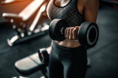 Vücut geliştirici spor salonunda halterlerle çalışıyor..