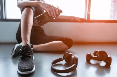 Eğitimden sonra dinleniyorum. Spor salonunda otururken gözlerini kaçıran güzel bir genç kadın. Spor yapmaya ara veren genç bir bayan..