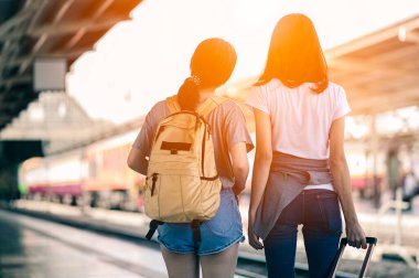 Tren istasyonunda bavulu çeken genç bir kadın. Taşıyıcıyı beklerken bavuluyla gezen adam. Uzayı kopyala.