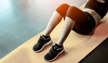 Fitness kadını mekik egzersizi yapıyor. Kadın kişisel antrenörle karın kası egzersizi yapıyor.