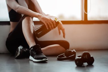 Eğitimden sonra dinleniyorum. Spor salonunda otururken gözlerini kaçıran güzel bir genç kadın. Spor yapmaya ara veren genç bir bayan..